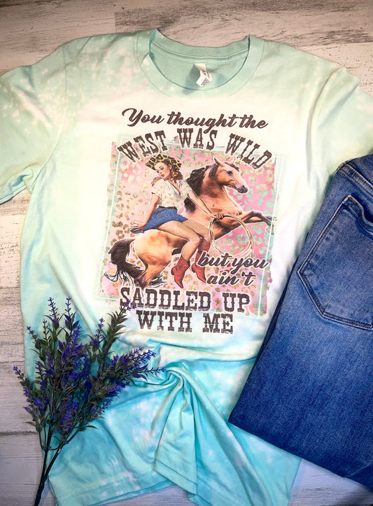 Product details  Custom sublimated tee that reads “You thought the West Was Wild but you haven’t saddled up with me" Pressed on a bella canva shirt Short sleeve  Fits true to size Contact us about a custom color shirt.   *Colors may vary slightly due to monitor resolution and lighting* Southern Bliss Boutique
