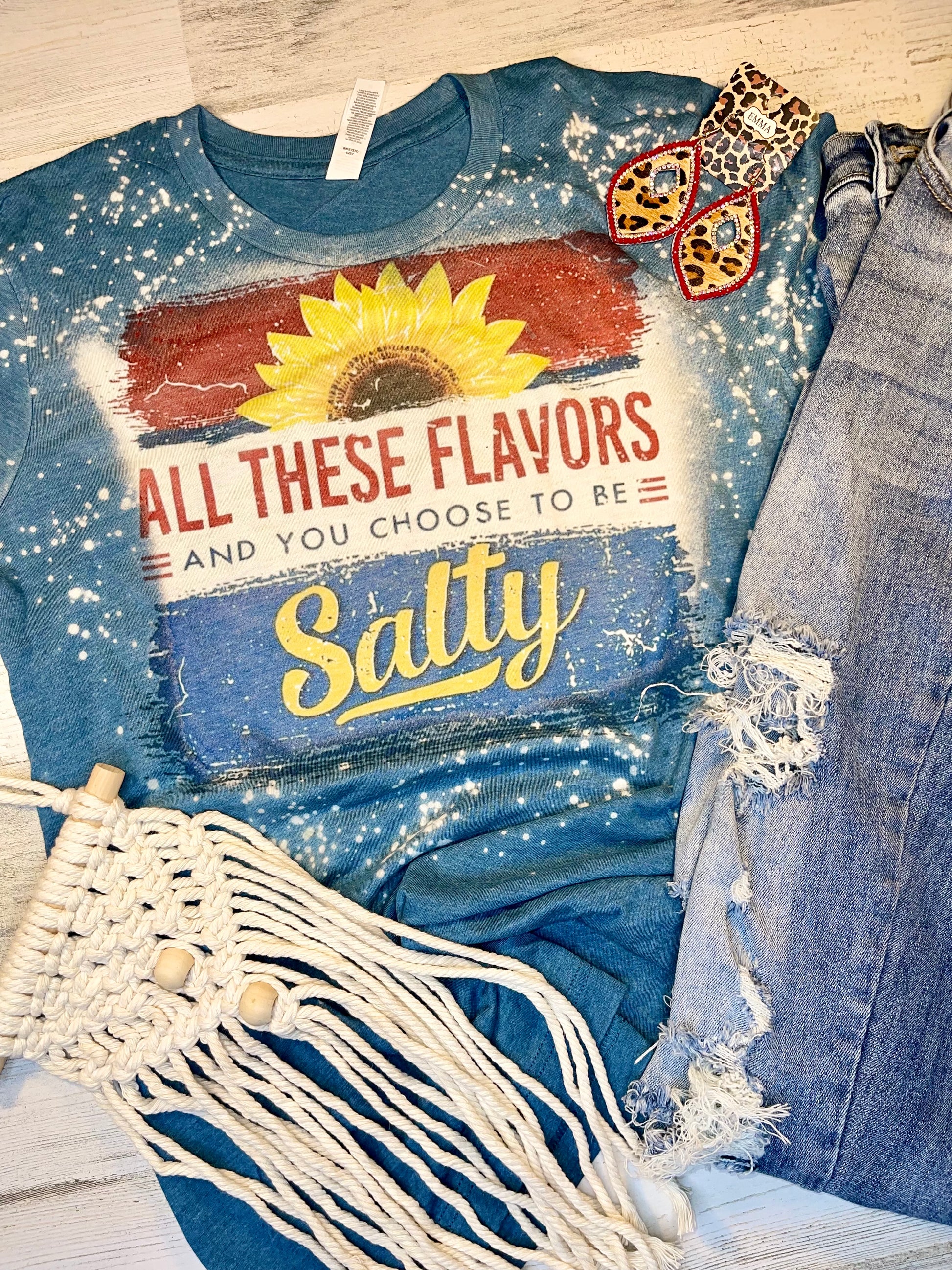 Product details Custom sublimated tee that reads "All These Flavors and You Choose To Be Salty" Pressed on a Bella Canva shirt Short sleeve  Fits true to size Contact us about a custom color shirt.   *Colors may vary slightly due to monitor resolution and lighting* Southern Bliss Boutique