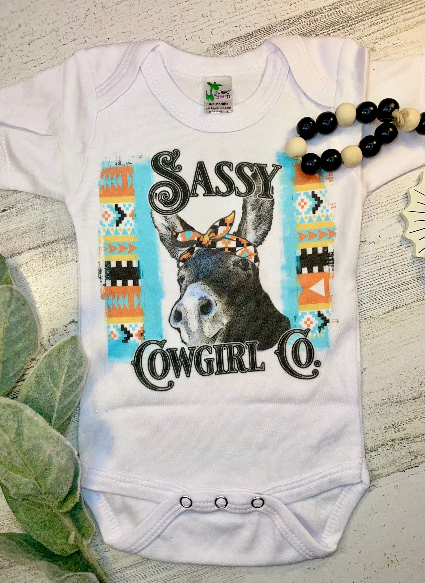 Product details  Custom sublimated  onesie that reads "Sassy Cowgirl Co." Pressed on a Laughing Giraffe Short sleeve  Fits true to size Contact us about a custom color shirt.   *Colors may vary slightly due to monitor resolution and lighting* Southern Bliss Boutique